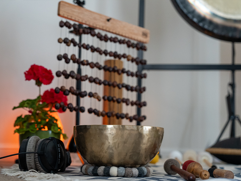 Sound healing studio setup with singing bowls, headphones, and meditation tools